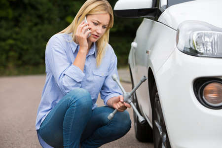 Female Motorist Phoning For Help After Breakdown