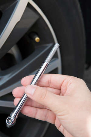 Close Up Of Checking Car Tyre Pressure Using Gauge