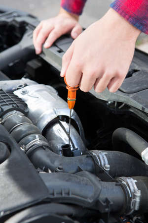 Checking Car Engine Oil Level Under Hood With Dipstickの写真素材