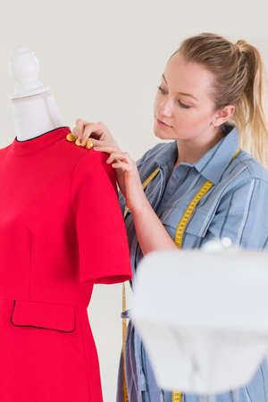 Female Fashion Designer Working On Mannequin In Studio