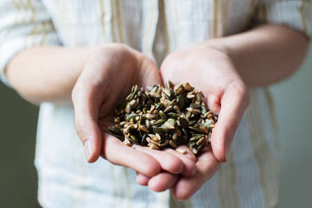 Close Up Of Woman Holding Handful Of Healthy Seedsの写真素材