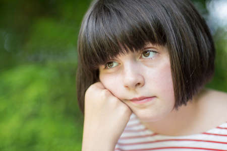 Close Up Of Unhappy Girl Sitting Outdoorsの写真素材