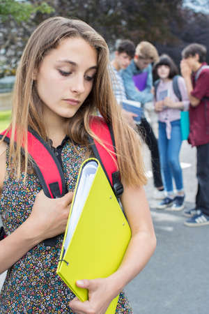 Unhappy Girl Being Gossiped About By School Friendsの写真素材