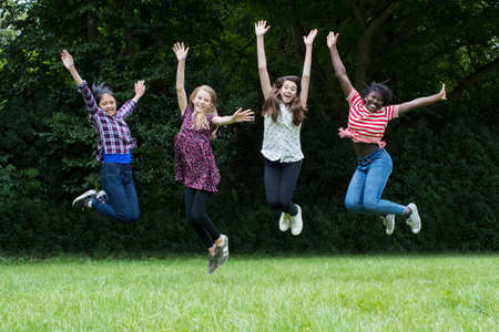 Group Of Female Teenage Friends Leaping In The Airの写真素材