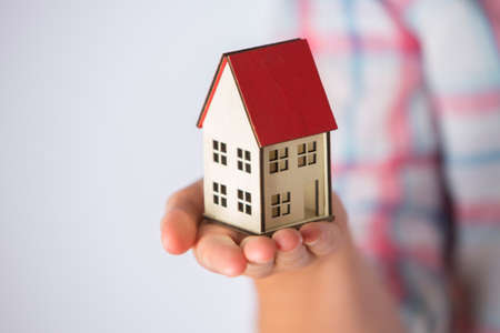 Close Up Of Woman Holding Model Wooden Houseの写真素材