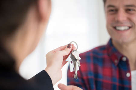 Man Collecting Keys To New Home From Female Realtorの写真素材