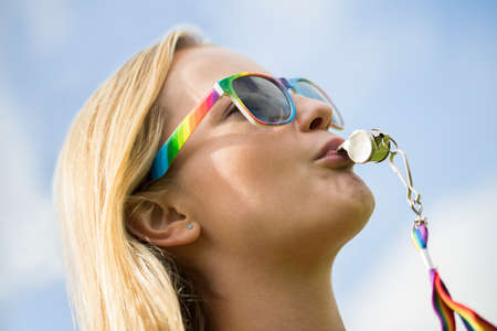 Young Woman Blowing Whistle On Gay Pride Paradeの写真素材