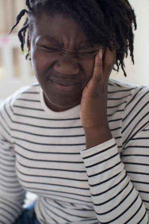 Teenage Girl Suffering With Headache In Bedroomの写真素材