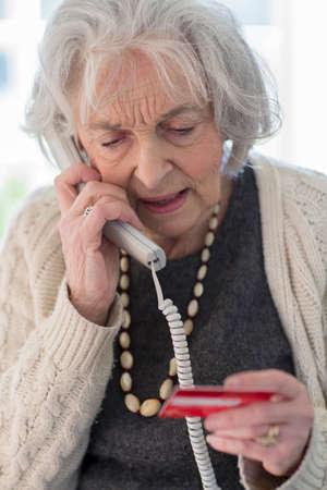Senior Woman Giving Credit Card Details On The Phone