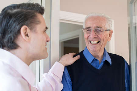 Man Checking On Elderly Female Neighborの写真素材