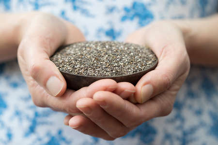Close Up Of Woman Holding Bowl Of Chia Seedsの写真素材