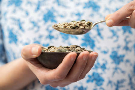 Close Up Of Woman Holding Bowl Of Mixed Seedsの写真素材
