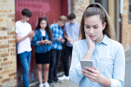 Worried Teenage Girl Being Bullied By Text Messageの写真素材