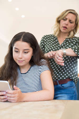 Mother Arguing With Teenage Daughter Over Use Of Mobile Phoneの写真素材