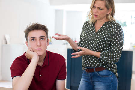 Fed Up Teenage Boy Being Nagged By Mother At Homeの写真素材
