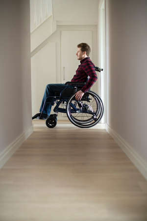 Close Up Of Man Sitting In Wheelchair At Home By Window