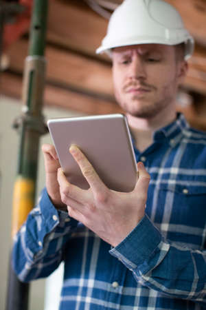 Architect Inside House Being Renovated Using Digital Tabletの写真素材