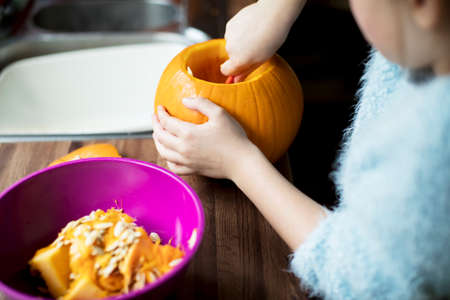Close Up of Girl Hollowing Out Pumpkin To Make Halloween Lanternの写真素材