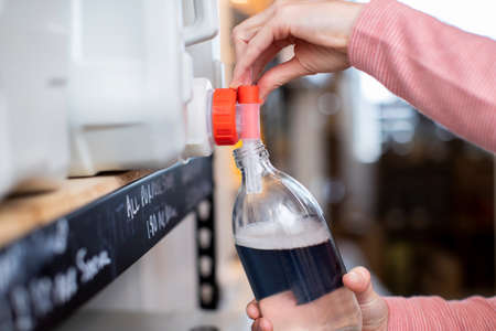 Close Up Of Woman Filling Container With Cleaning Product In Plastic Free Grocery Storeの写真素材