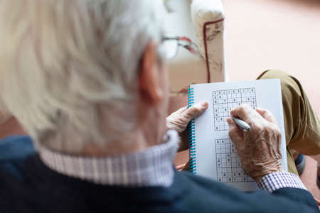 Senior Man Doing Sudoku Puzzle At Homeの写真素材