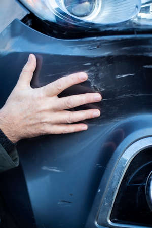 Close Up Of Driver Inspecting Damage To Car After Accidentの写真素材