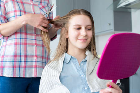 Mother Cutting Teenage Daughters Hair At Home During Lockdownの写真素材