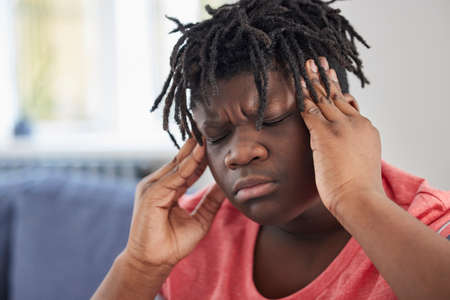 Teenage Boy Suffering With Headache At Homeの写真素材