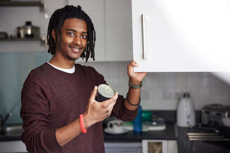 Portrait Of Male University Or College Student Cooking Meal In Campus Kitchenの写真素材