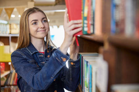 Young Woman Or Student Browsing Books In Book Storeの写真素材