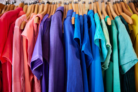 Colourful Sustainable Clothing Hanging On Rail In Charity Or Thrift Store Selling Sustainable Fashionの写真素材