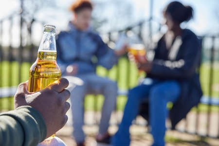 Close Up Of Underage Teenagers Drinking Alcohol In Parkの写真素材
