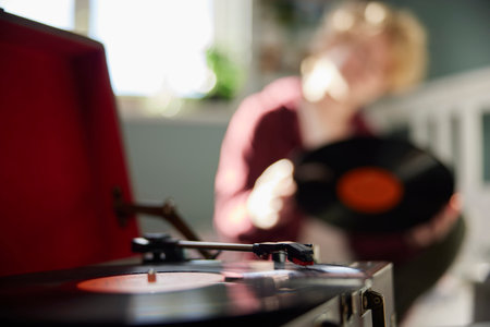 Teenage Girl Playing Vinyl Records On Record Player At Home In Bedroom With Focus On Foregroundの写真素材
