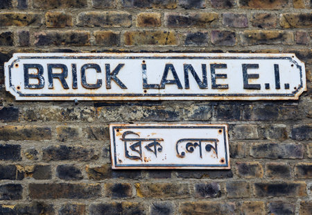 Close Up Of Brick Lane Street Sign In London UK With Name Written In Both English And Bengali - famouse for street market and restaurantsの写真素材