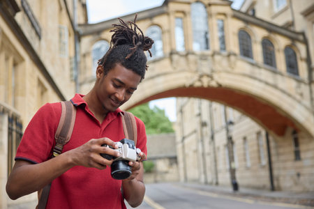 Young Man Travelling On Vacation Taking Photo With Camera When Sightseeing In Oxfordの写真素材