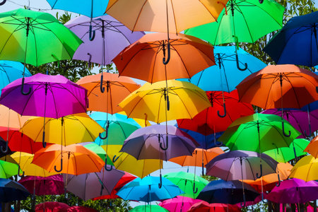Colorful Umbrellas Hanging Outdoors.Beautiful vibrant umbrellas canopy decoration in a sunny outdoor...