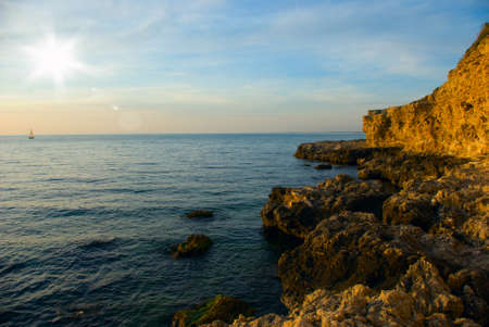 Rocks on the sea coast, at sunsetの写真素材