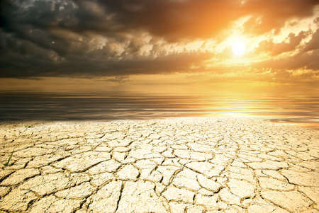 A piece of desert land against the sea and sunset