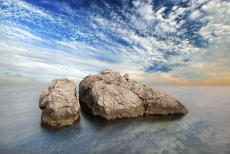 Two small rock in the sea and the sunset sky. natural sunset