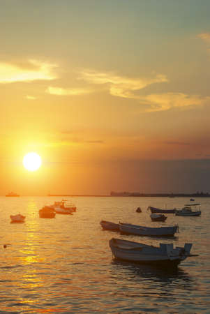 Fishing boats against the setting sunの写真素材