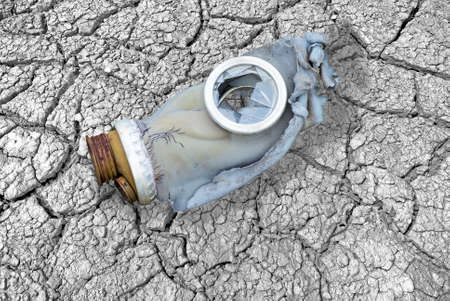 Dirty broken gas mask on cracks, symbolizing the "end"の写真素材