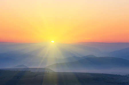 The sun with rays rises over the mountains. natural landscapeの写真素材