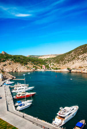 Sea bay with yachts in the background of mountains and blue skyの写真素材
