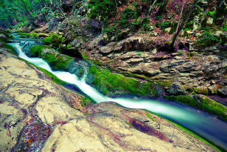Mountain forest stream flowing between the rocks. Vintage styleの写真素材