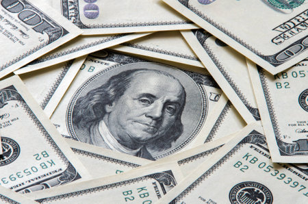 The concept of a plurality of one-hundred dollar bills with a portrait of Franklin in the center