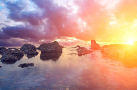 Big stones, sea and unusually brightly sunset. The natural landscapeの写真素材