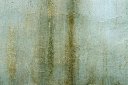 Old green plaster with traces of the impact of bad weather. textural composition
