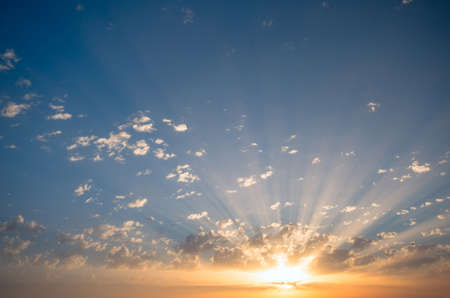 The sun's rays make their way through the clouds at sunset, painting them. Natural Dawn Compositionの写真素材