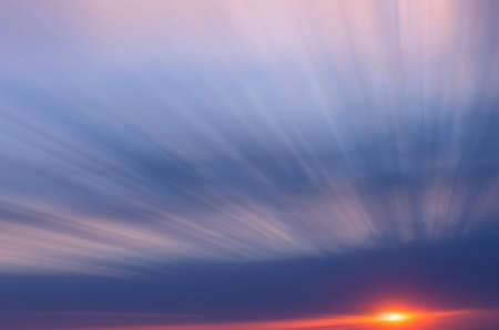 The setting sun and clouds are blurred in motion. Abstract dawn composition