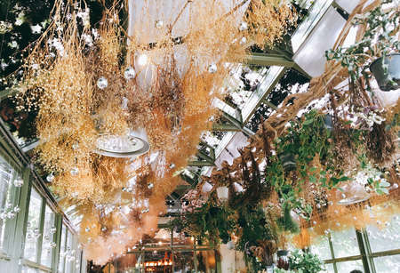 Silver Christmas balls with dry flowers on the glass roof background, silver balls, vintage tone.の写真素材