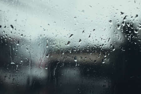 Rain drops on window glass with blurred in the background, Vintage tone.の写真素材